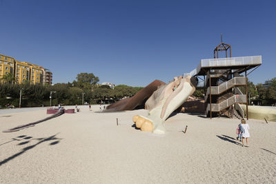 Lifeguard hut on sand against clear sky