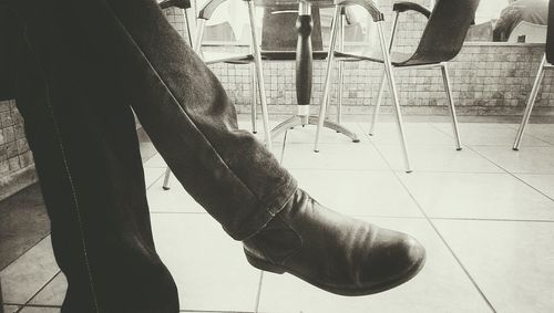 Low section of man standing on tiled floor