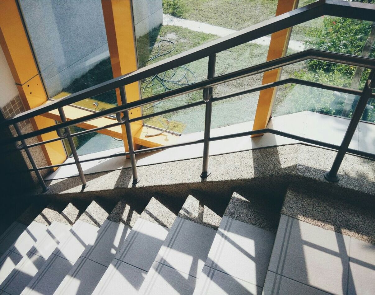 indoors, architecture, built structure, window, glass - material, sunlight, shadow, tiled floor, reflection, transparent, railing, flooring, pattern, day, modern, steps, geometric shape, building exterior, high angle view, building
