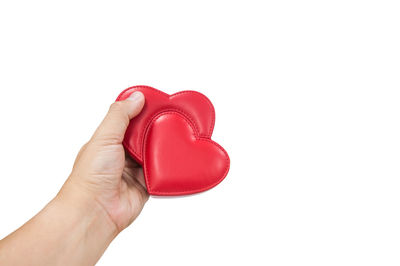 Close-up of hand holding heart shape against white background