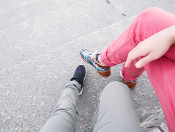 Low section of woman sitting on road