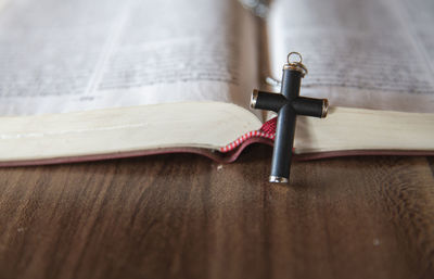 Close-up of bible with cross on table