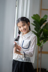 Portrait of smiling girl standing at home