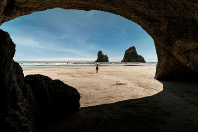 Rock formations on beach against sky