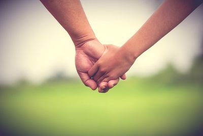 Cropped image of couple holding hands