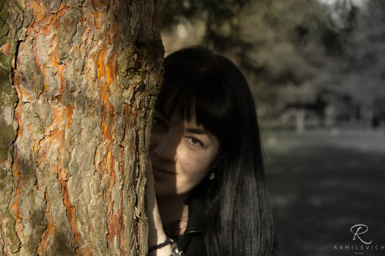 CLOSE-UP OF BEAUTIFUL YOUNG WOMAN WITH TREE