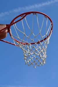 Low angle view of basketball hoop against blue sky