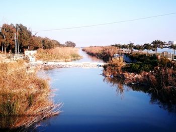 Scenic view of lake against clear blue sky