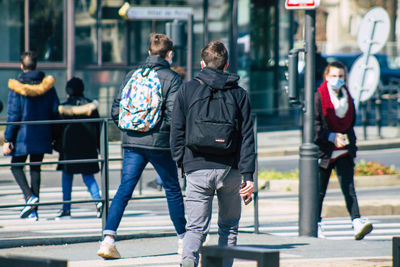 Rear view of people walking in city