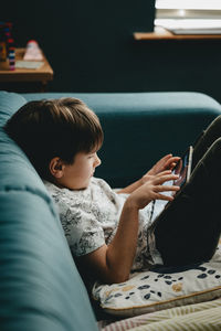 Side view of boy sitting at home