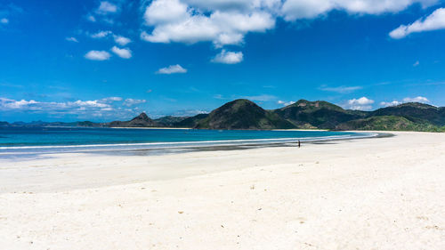 Scenic view of beach against blue sky