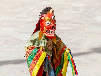 Low section of man standing against multi colored umbrella