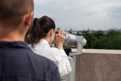 Side view of man photographing through binoculars