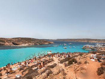 Panoramic view of people on beach against clear sky