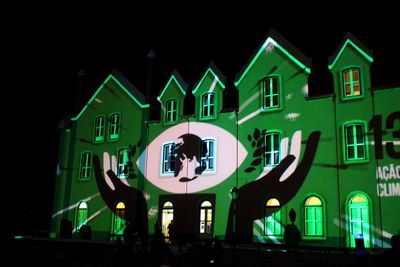 Low angle view of illuminated house against sky at night