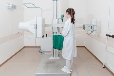 Rear view of woman standing in bathroom