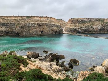 Scenic view of rocks in sea against sky