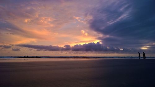 Scenic view of beach against dramatic sky