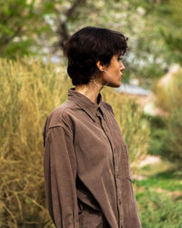 Side view of young woman standing on field