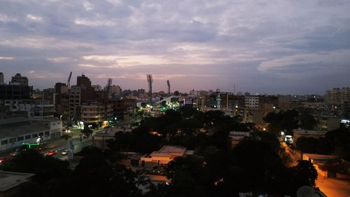 High angle view of city buildings against cloudy sky