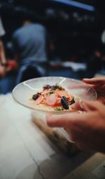 Cropped hands holding food in plate