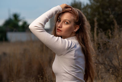 Portrait of young woman standing on field