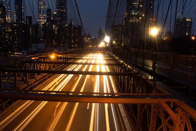 Illuminated railroad tracks against sky at night