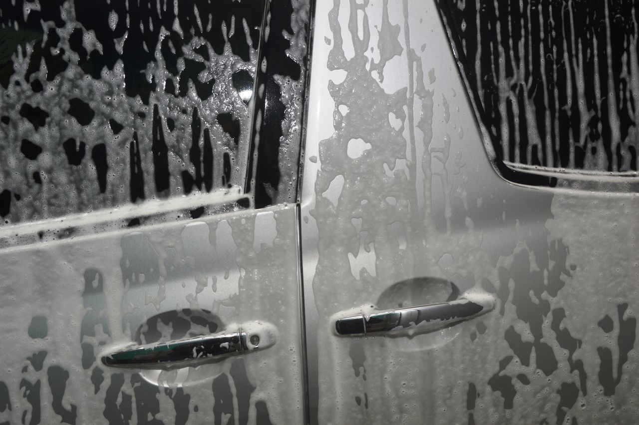 CLOSE-UP OF WET WINDOW AGAINST CAR