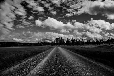 Empty road on field against sky