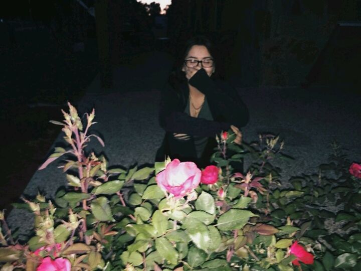 WOMAN STANDING WITH PINK FLOWERS