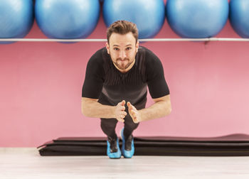 Portrait of man exercising on floor in gym