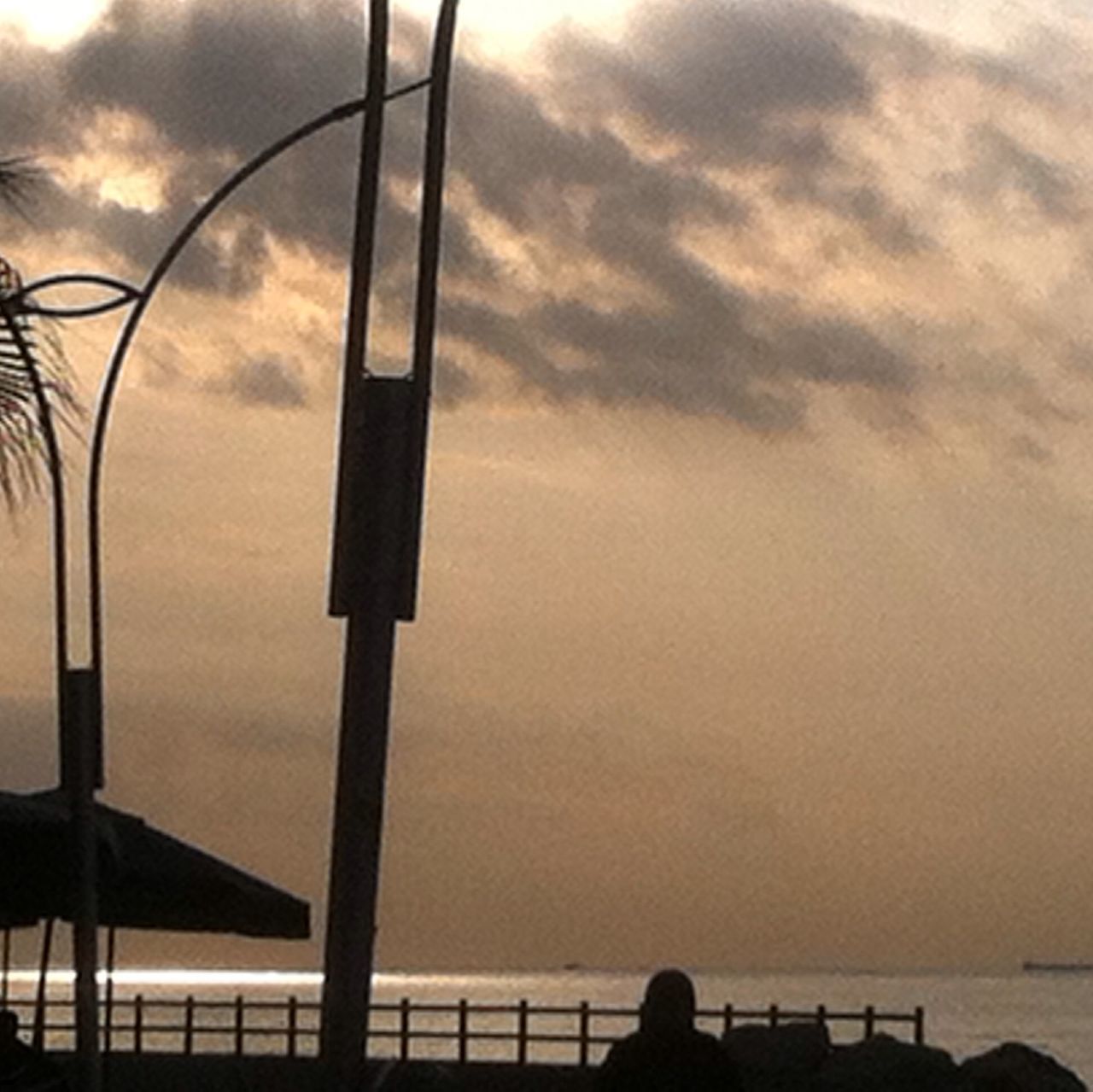 sky, sea, cloud - sky, water, horizon over water, sunset, silhouette, cloud, cloudy, railing, nature, beach, reflection, tranquility, scenics, low angle view, metal, outdoors, beauty in nature, tranquil scene