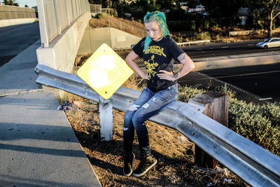 Hipster woman sitting on railing