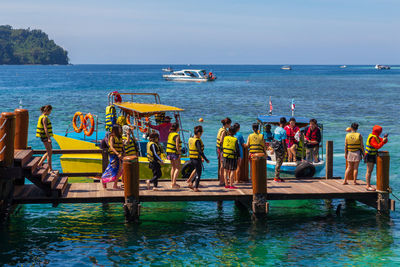 People standing in sea against sky