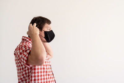 Side view of a young man against white background