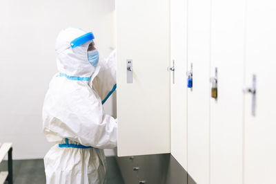 Mid adult man keeping bag inside locker at hospital