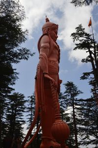 Low angle view of sculpture against cloudy sky