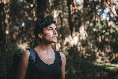 Portrait of young woman looking away in forest