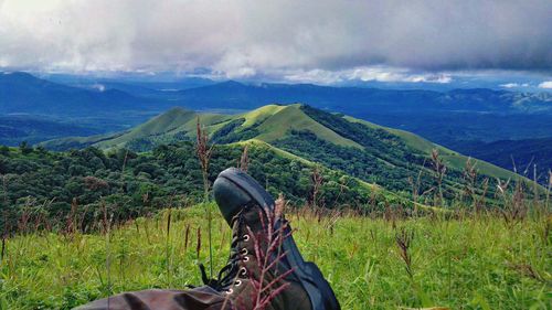 Scenic view of grassy field against cloudy sky