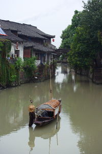 Boat moored on lake against sky