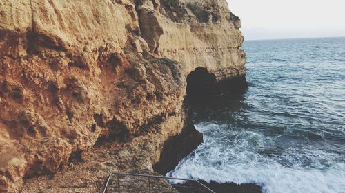 Rock formations by sea against sky