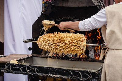 Preparing lithuanian tree cake, šakotis or baumkuchenas, polish sekacz, belarusian bankucha