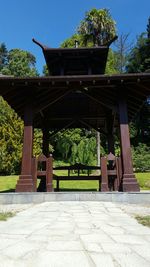 Gazebo in park by building against sky