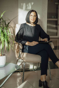 Work-life-balance, businesswoman in a chair in the lobby with a tablet