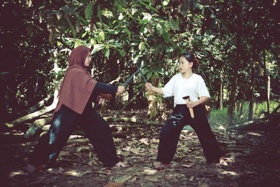 Full length of women fighting in forest