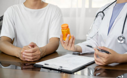 Midsection of doctor examining patient at clinic