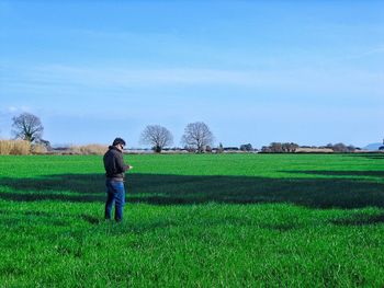 Rear view of woman standing on grassy field