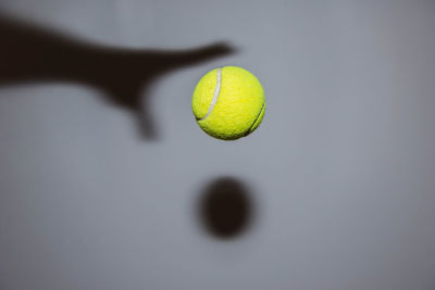 Close-up of a shadow and a tennis ball