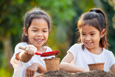 Happy girls gardening with shovel