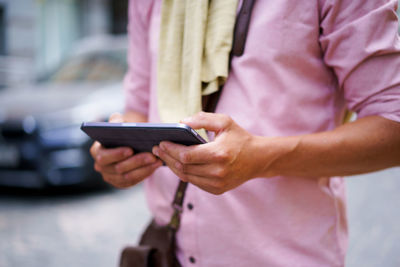 Midsection of man using mobile phone